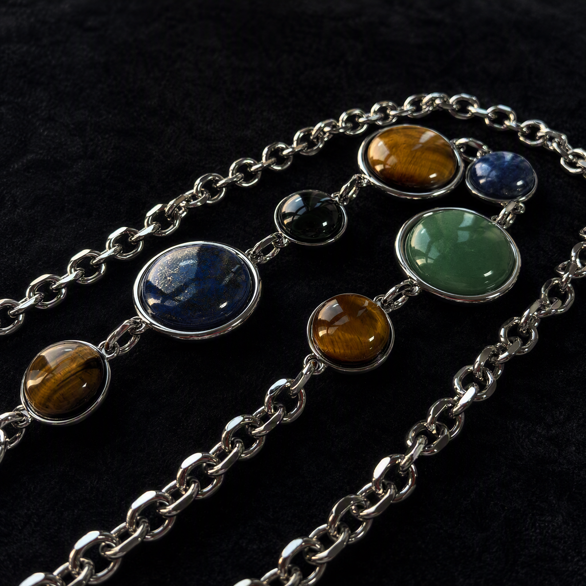 WOOJIN ATELIER — Silver rhodium NF chain with mixed cabochon stone settings. Tiger Eye, Lapis, Malachite, and Aventurine hand-set in bezel mounts. Detail view of multi-component chain assembly for luxury handbag hardware.

